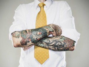 business man with rolled up sleeves showing tattoos on forearms